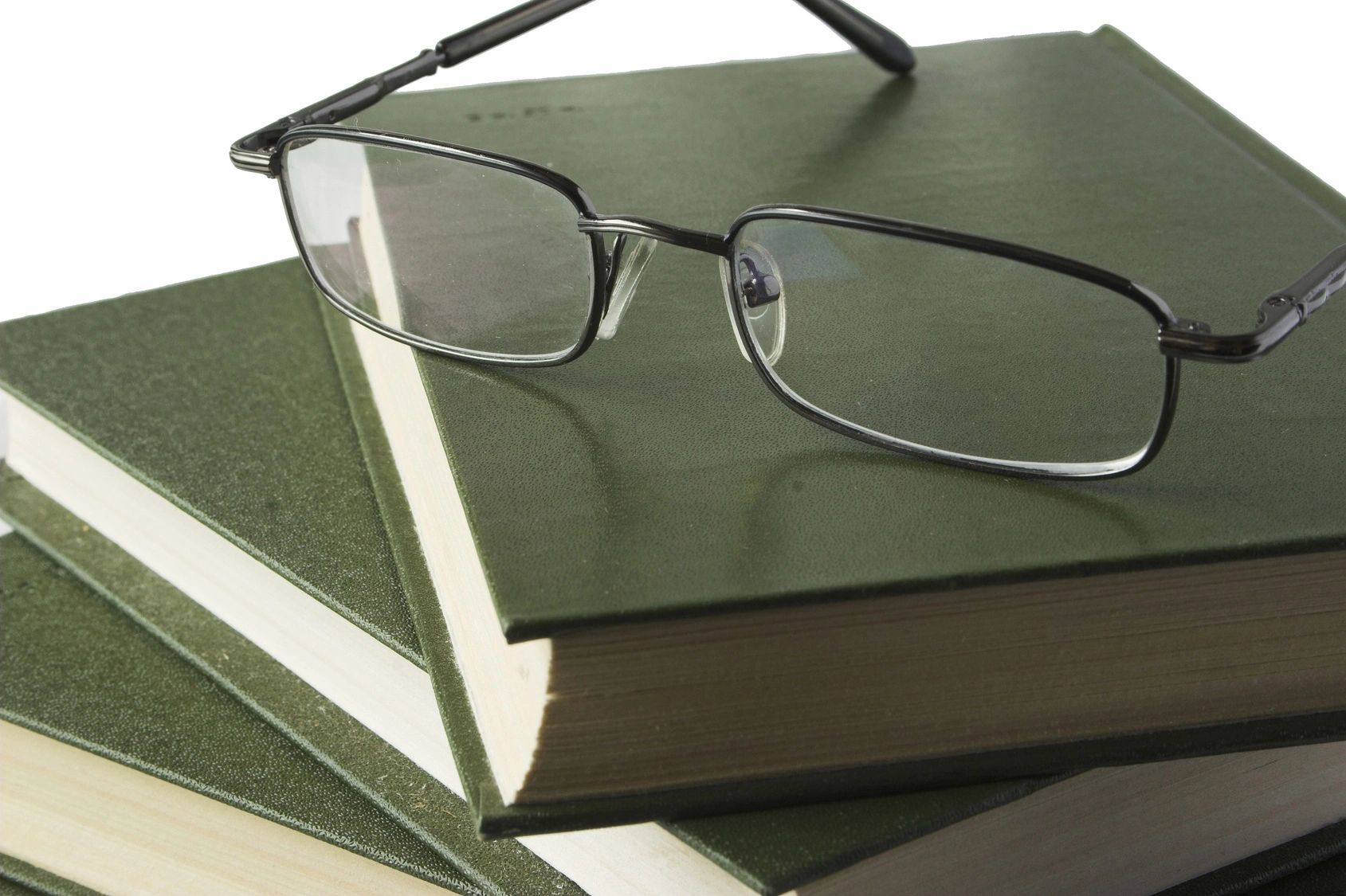 A pair of glasses sitting on top of some books.